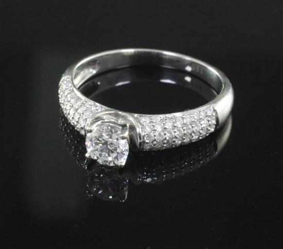 A modern claw set single stone diamond ring with diamond encrusted shoulders, size O.
